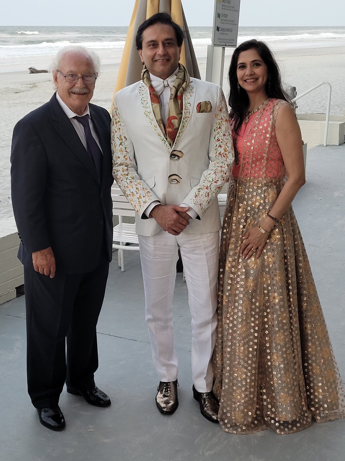 Dr. Arun Gulani, center, wears a suit specially painted by artist Mario Della Penta, left, during the Beaches, A Celebration of the Arts event. At right is Dr. Suparna Gulani.